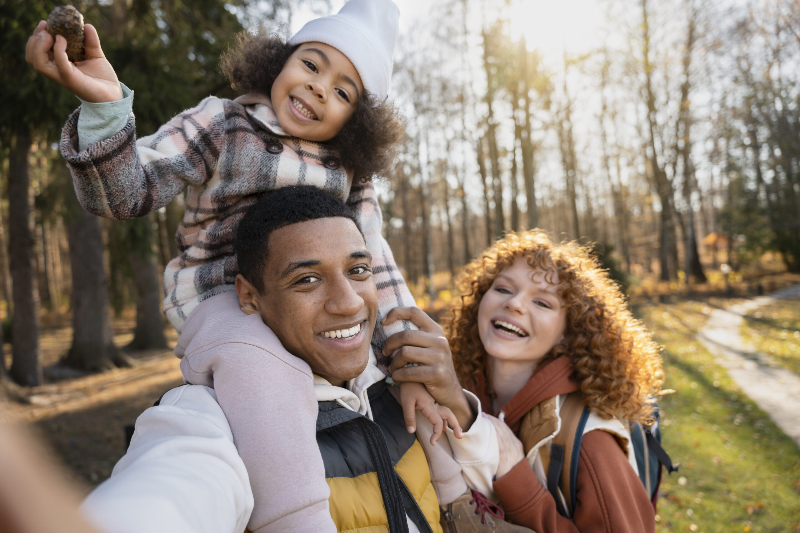 happy family of 3 outside